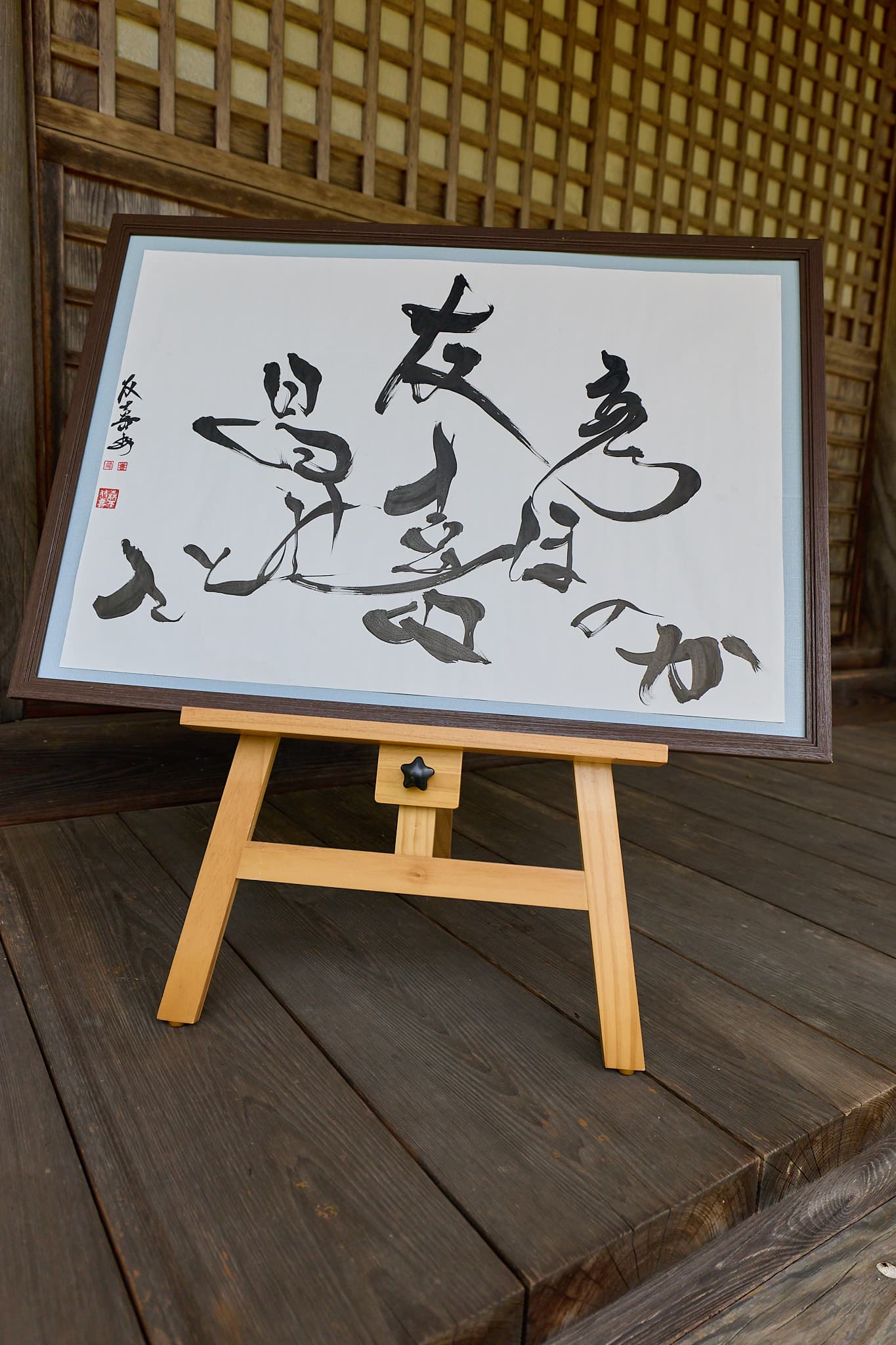 木のイーゼルに掛けた森下友喜の額装作品