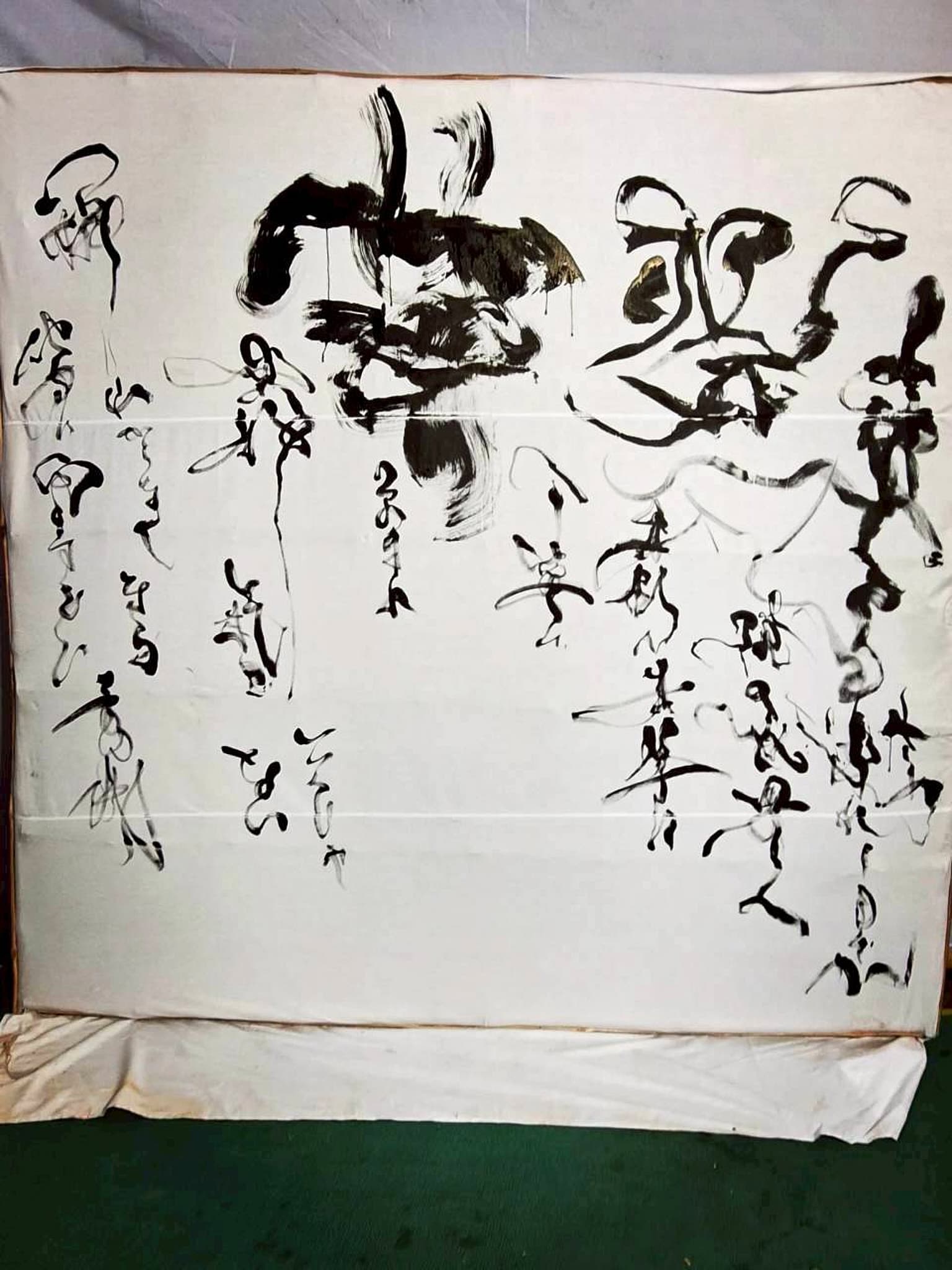 縦長の大型紙に大字「火炎車」と細字の草書を配した作品