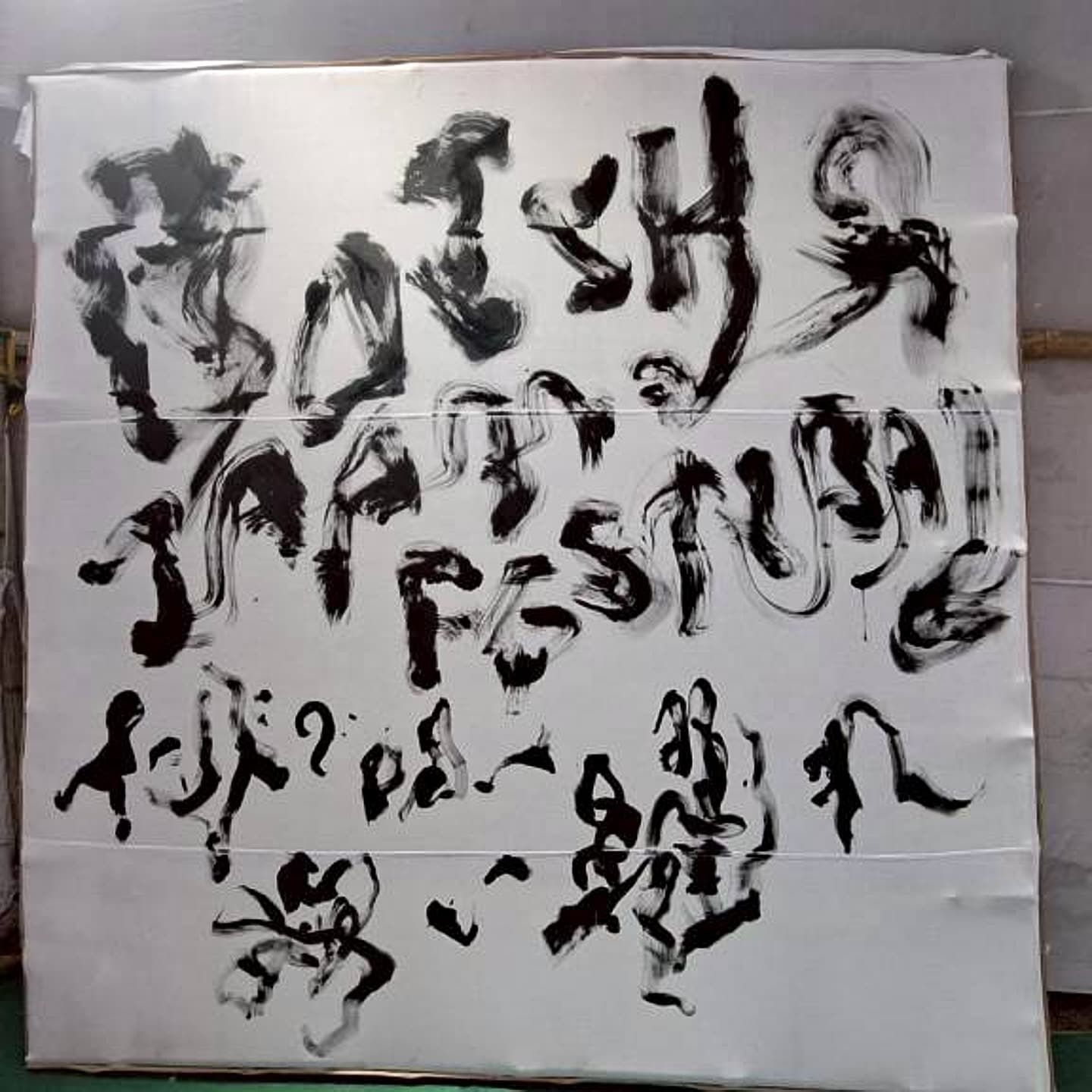 白い大画面に墨で記した「オリッサジャパンフェスティバル」「インドで歌い舞い踊れ」の文字
