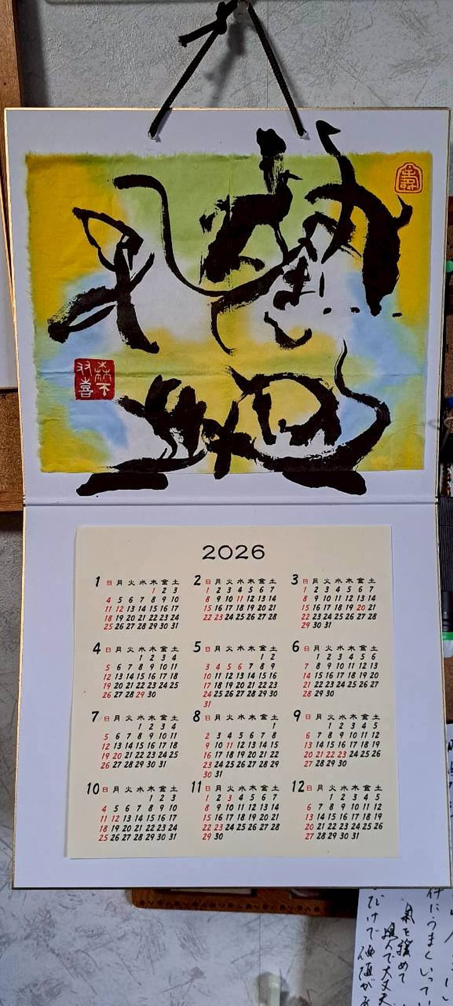 彩色背景の大字書を配した2026年の壁掛けカレンダー