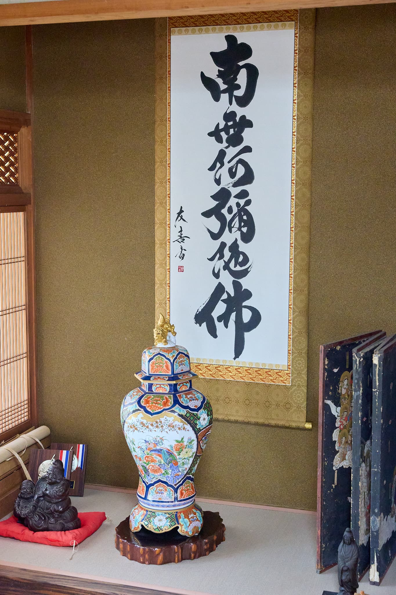 床の間に掛けた掛軸「南無阿弥陀佛」。友喜書の署名と朱の落款、色絵の壺